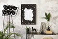 Modern composition of living room interior with mockup poster frame, black consola, modern lamp, plants, black dog, vase with Royalty Free Stock Photo