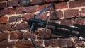 A modern compound crossbow handgun on the red brick wall background. Old weapon concept.