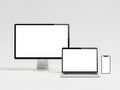 Modern computer devices on a white background including a desktop, laptop, and smartphone Royalty Free Stock Photo