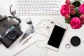 Modern computer keyboard, pink flowers and photo camera on white Royalty Free Stock Photo