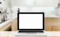 Modern computer,laptop with blank screen on Wood table top on blurred kitchen background Royalty Free Stock Photo