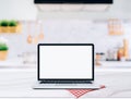 Modern computer,laptop with blank screen on Wood table top on blurred kitchen background Royalty Free Stock Photo