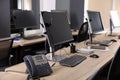 Modern computers with headsets and stationary phone on wooden desk in office. Hotline service Royalty Free Stock Photo