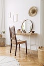 Modern concept in design home interior of open space with wooden desk, coffee table, sofa, chair, plants, mirror, macrame.