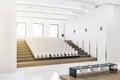 Modern concrete auditorium interior with seatings, city view and daylight. Training concept.