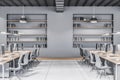 Modern concrete coworking office interior with multiple workplaces and bookcase shelves with books and folders. Commercial and Royalty Free Stock Photo