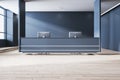 Modern concrete office lobby interior with reception desk and computer, wooden flooring, window with city view and daylight. Royalty Free Stock Photo