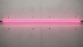 Modern concrete wall with embedded pink neon light strip and circular indentations Royalty Free Stock Photo