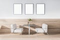 Modern concrete and wooden art deco cafe interior with furniture, daylight and empty mockup frames on wall. Royalty Free Stock Photo