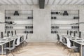 Modern concrete and wooden coworking office interior with multiple workplaces and bookcase shelves with books and folders. Royalty Free Stock Photo