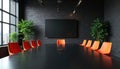 Modern conference room with black table and orange chairs. Plants and brick wall create stylish workspace. Large screen for Royalty Free Stock Photo
