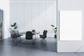 Modern conference room with chairs, table, and a blank poster mockup on a white wall, empty corporate meeting space concept, 3D Royalty Free Stock Photo