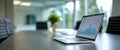 Modern conference room with laptop displaying financial data and charts on table in bright workspace Royalty Free Stock Photo