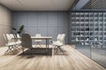 A modern conference room with a wooden table, white chairs, and shelves, set against a grey wall, reflecting a corporate design. Royalty Free Stock Photo