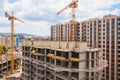 Modern construction site with cranes. Incomplete building construction
