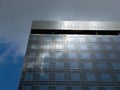 Modern contemporary high-rise office building exterior against blue sky with clouds. Reflection of sky on glass windows of Royalty Free Stock Photo