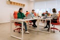 Modern corporate office open space with busy male and female staff employees using laptop computers sitting at work in Royalty Free Stock Photo