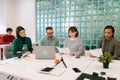 Modern corporate office open space with busy male and female staff employees using laptop computers sitting at work in Royalty Free Stock Photo