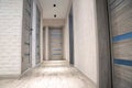 Modern corridor in an apartment after renovation in gray tones. Gray interior doors and black LED lights on the ceiling. white Royalty Free Stock Photo