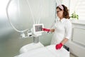 Beautiful beautician operating cosmetology equipment in modern beauty clinic. Spa concept