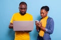 Modern couple browsing internet on laptop and smartphone Royalty Free Stock Photo