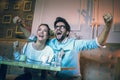 Modern couple in cafe looking football match on tv in cafe. Royalty Free Stock Photo