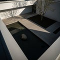 Modern courtyard featuring a minimalist design with white walls and clean lines. A Royalty Free Stock Photo