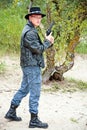 Modern cowboy with revolver standing on sand