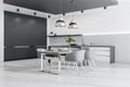 Modern cozy bright furnished kitchen with chairs, table and lamps, white concrete floor and a black empty wall. Interior design Royalty Free Stock Photo