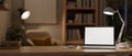 A modern, cozy home office at night with a white-screen laptop computer mockup on the table Royalty Free Stock Photo