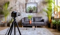 A modern and cozy photo studio with daylight, a professional camera on a tripod, green plants and minimalistic furniture