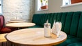 A modern cozy restaurant with colorful upholstered chairs and comfortable sofas. There are napkins and cutlery on the table. Table Royalty Free Stock Photo