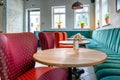 A modern cozy restaurant with colorful upholstered chairs and comfortable sofas. Unusual cafe design with rough concrete walls and Royalty Free Stock Photo