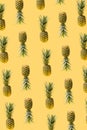 Modern, creative pattern made of many fresh exotic funky ananas against illuminated yellow background. Levitating natural organic Royalty Free Stock Photo