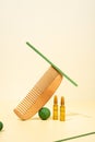 Modern Creative still life, balance photo. Cosmetic ampoules with serum for hair growth, restoration. Hair comb, green props on a
