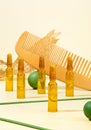 Modern Creative still life photo. Cosmetic ampoules with serum for hair growth, restoration. Hair comb, green props on a beige