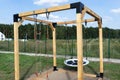 A modern cube playground made of wood and metal corners, standing in the yard behind the house.