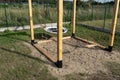 A modern cube playground made of wood and metal corners, standing in the yard behind the house.