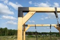 A modern cubic playground made of wooden logs and metal corners, visible steel corners.