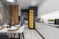 Modern cuisine in black in the dining table and kitchen appliances