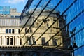 Modern glass curtain wall building facade with strong reflections. classic old building mirrored in the glass