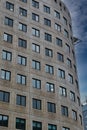 Modern curved office building facade against a clear blue sky in Leeds, UK