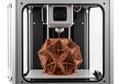 Modern 3d printer creating an intricate geometric copper-colored object in progress Royalty Free Stock Photo