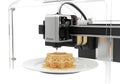Modern 3d printer creating intricate honeycomb patterned food on a white plate Royalty Free Stock Photo