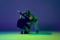 Modern dance concept. Energetic couple of two young woman dancing contemporary dance on gradient blue-green background Royalty Free Stock Photo