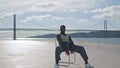 Modern dancer sitting chair at sea background. Professional man looking camera Royalty Free Stock Photo