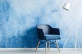 Modern dark blue chair and white metal lamp against ombre wall i