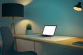 Modern dark blue designer office workplace with various items, empty white mock up laptop screen, decorative plant and lamp. Royalty Free Stock Photo