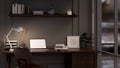 Modern dark office working space at night with laptop mockup, office supplies and decor on table Royalty Free Stock Photo