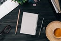 Modern dark wood office desk table with laptop, smartphone and other supplies with cup of coffee. Blank notebook page for input Royalty Free Stock Photo